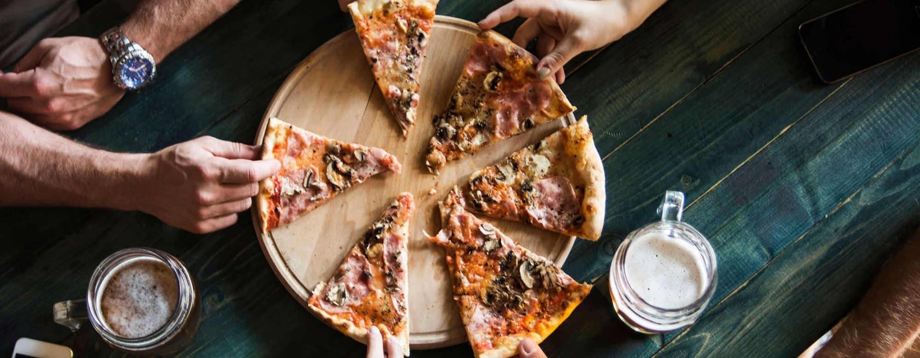 a group of people eating pizza