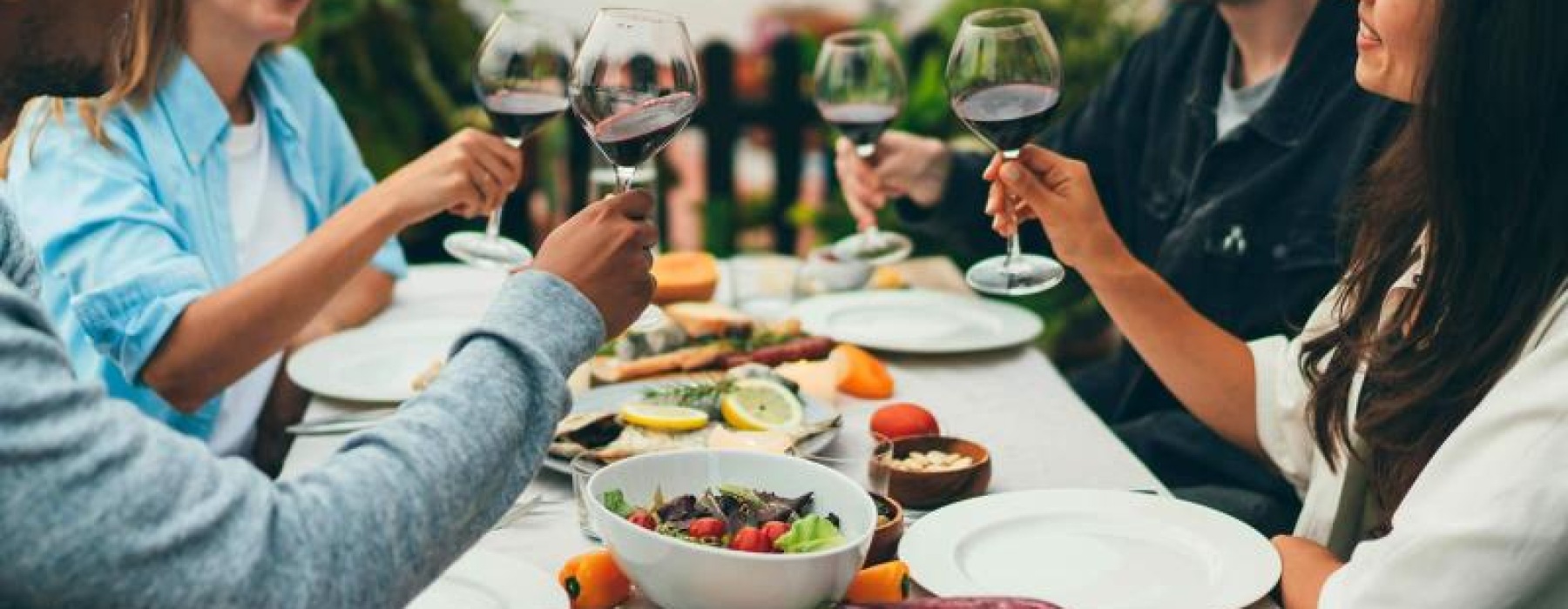 a group of people having a meal around an outdoor table